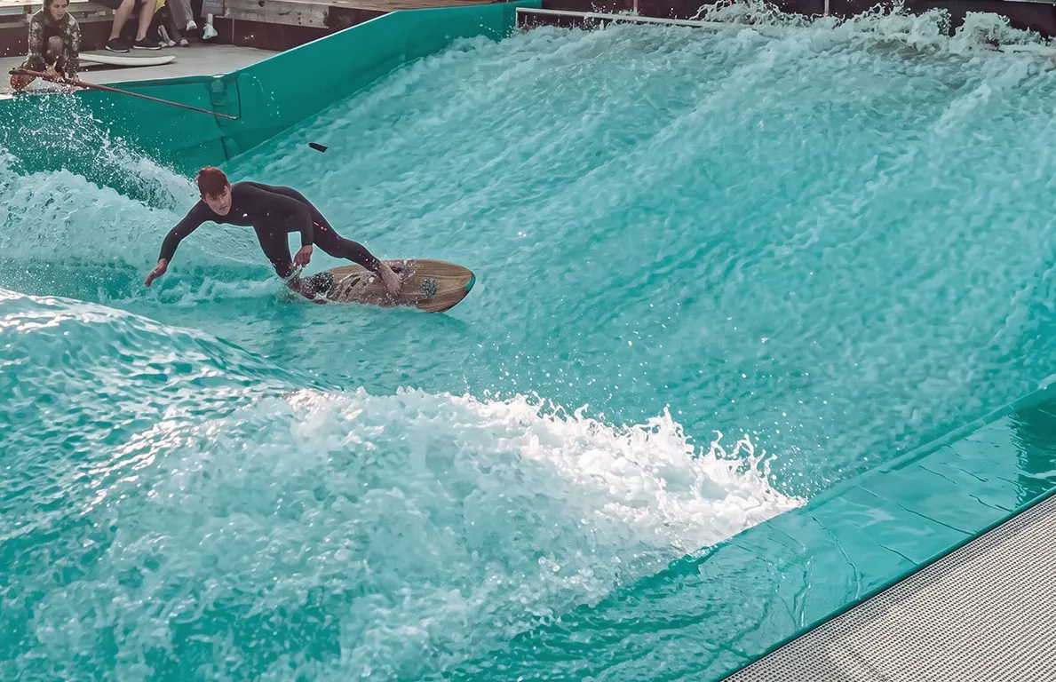 Surfista pegando onda no simulador de ondas estáticas